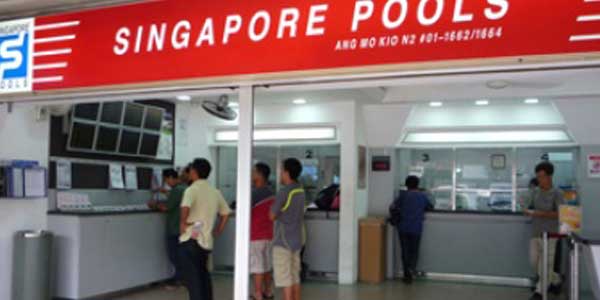 Singapore Pools branch with people looking at results screens and others placing entries
