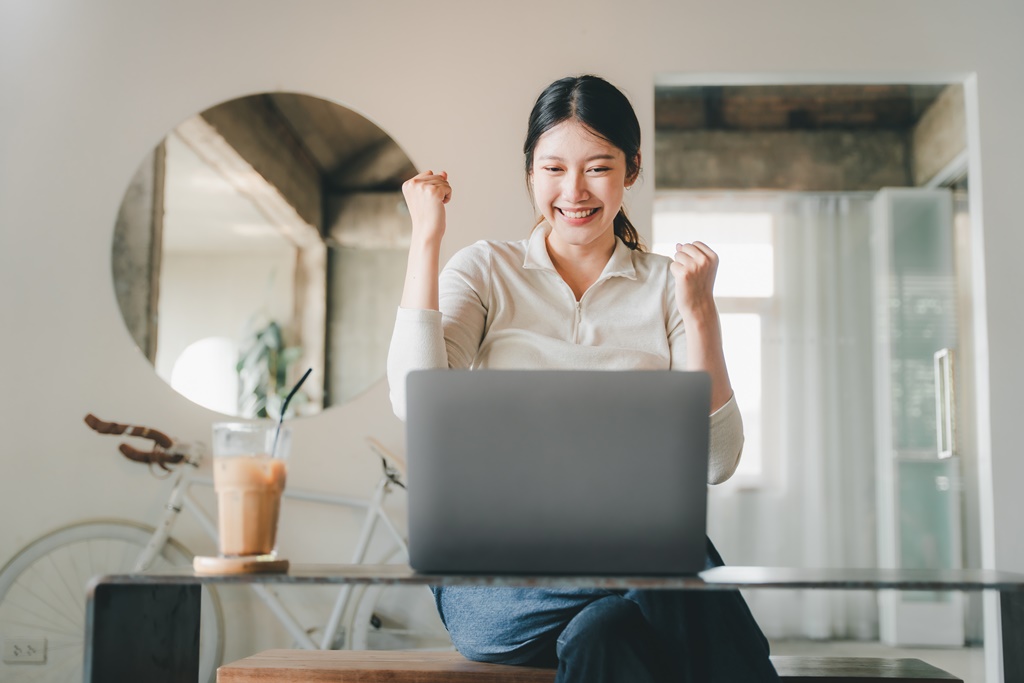 Excited woman learning simple tips online on how to get out of a personal loan within the personal loan repayment period
