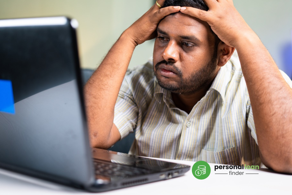 Sad man staring at laptop wondering why his personal loan application was rejected
