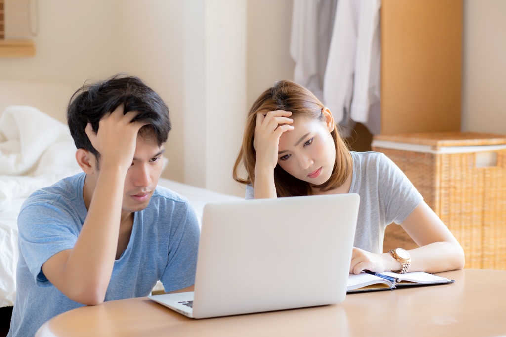 Stressed couple in debt wondering if a personal loan is a secured loan or unsecured loan