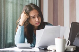 Woman in debt wondering if foreclosure charges on her personal loan is worth paying for or not